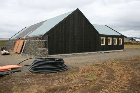 Svart hús með nýju þaki